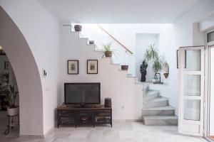 sala de estar con escalera y TV en La Casa de Lucía en Ayamonte