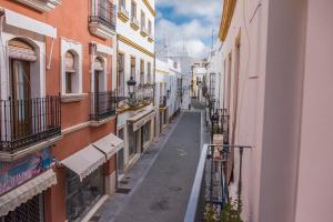 un callejón vacío en una ciudad con edificios en La Casa de Lucía en Ayamonte
