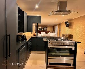 a kitchen with black cabinets and a stove top oven at St Tropez Guest House in Phuthaditjhaba