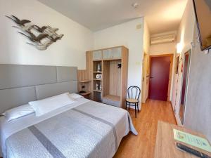 um quarto com uma cama, uma mesa e uma cadeira em Hotel Betty em Rimini