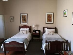 a bedroom with two beds and a table with a lamp at Walkerbouts Inn in Rhodes