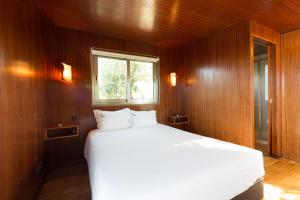 a bedroom with a white bed and a window at Encostas do Côa TER -HOTEL in Pinhel