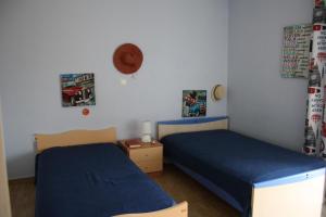 1 dormitorio con 2 camas y un sombrero en la pared en Fourdeck Villa en Posidhonía