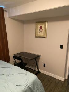 Un dormitorio con una mesa en la esquina con una cama en A cozy 1 bedroom suit, en Saskatoon