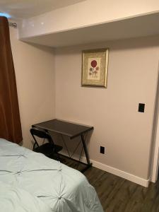 a bedroom with a table in the corner with a bed at A cozy 1 bedroom suit in Saskatoon