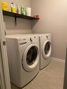uma máquina de lavar e secar roupa branca numa lavandaria em A cozy 1 bedroom suit em Saskatoon