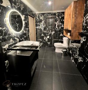 a black and white bathroom with a toilet and a sink at St Tropez Guest House in Phuthaditjhaba