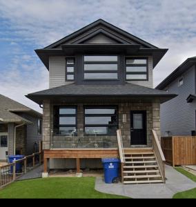a small house with a porch and a deck at A cozy 1 bedroom suit in Saskatoon