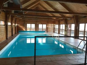 a large indoor swimming pool with blue water at Chalet Résivacances n°32 - La Joue du Loup in Le Dévoluy