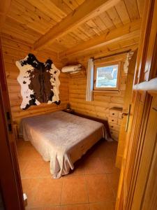 a small room with a bed in a log cabin at Chalet Résivacances n°32 - La Joue du Loup in Le Dévoluy