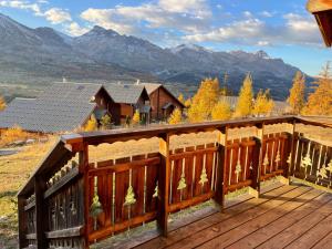 a wooden deck with mountains in the background at Chalet Résivacances n°32 - La Joue du Loup in Le Dévoluy