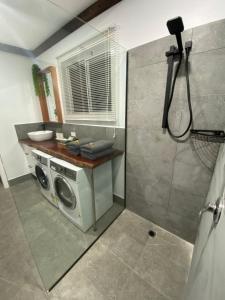 a bathroom with a washing machine and a shower at Preston Valley Country Cabin in Lowden +13 photos