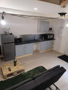 a living room with a couch and a kitchen at GITE les cactus logement indépendant 