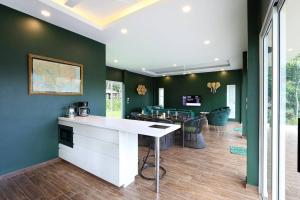 eine Küche mit grünen Wänden und einer weißen Arbeitsplatte in der Unterkunft Jungle So Chic, Private Paradise with Lake View in Ko Phangan