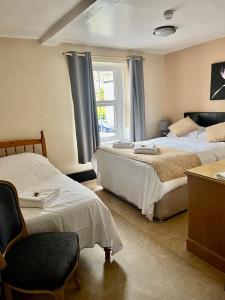 a bedroom with two beds and a window at Villa Bianca B&B in Penrith