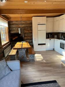 un soggiorno con tavolo e cucina di Rauhallinen kelohuoneisto lähellä palveluita, Peacefull Log apartment at Ylläs a Ylläsjärvi