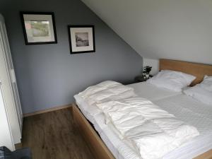 een bed in een slaapkamer met twee foto's aan de muur bij Ferienwohnung Abby in Butjadingen