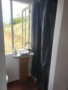 uma casa de banho com um lavatório e uma janela em Bellingen Hideaway Tiny Home- Breathe. Discover. Renew. em Bellingen