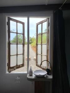 貝林恩的住宿－Bellingen Hideaway Tiny Home- Breathe. Discover. Renew.，一间带开放式窗户和水槽的浴室