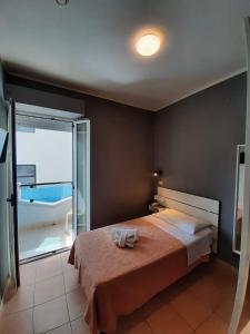 Hotel Originale by ALEhotels في ريميني: غرفة نوم مع سرير وإطلالة على المحيط