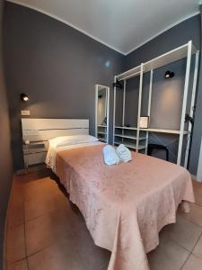 Hotel Originale by ALEhotels في ريميني: غرفة نوم عليها سرير وفوط