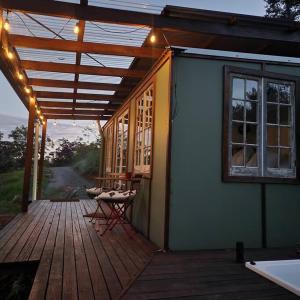 Casa con terraza con mesa y ventana en Bellingen Hideaway Tiny Home- Breathe. Discover. Renew., en Bellingen