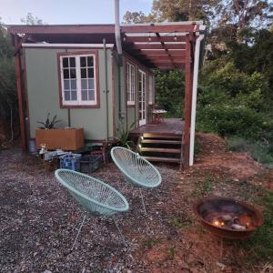 two chairs and a grill in front of a house at Bellingen Hideaway Tiny Home- Breathe. Discover. Renew. in Bellingen