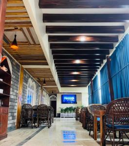 une salle à manger avec des tables, des chaises et une télévision dans l'établissement Himalayan Guest House, à Pokhara