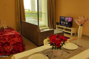 a living room with red flowers and a television at CQ1101- SELF CHECK-IN- WI-FI - NETFLIX-PARKING-BALCONY- CYBERJAYa, 2063 in Cyberjaya