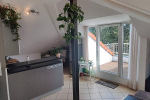 eine Küche mit einer Theke und einen Balkon mit einem Fenster in der Unterkunft Skyline-Blick über Darmstadts Martinsviertel in Darmstadt
