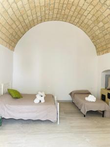 2 camas en una habitación con techo de ladrillo en Finestra sul Borgo Apt., en Acquarica del Capo