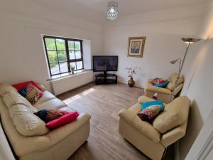 ein Wohnzimmer mit 2 Sofas und einem TV in der Unterkunft Brookmount House in Omagh