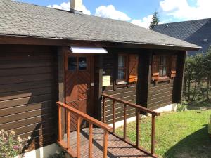 um chalé com um alpendre e uma porta de madeira em Chalet Cosy JMV em Les Angles