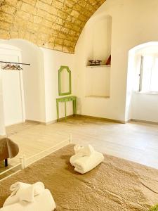 Habitación con 2 toallas blancas en el suelo en Finestra sul Borgo Apt., en Acquarica del Capo