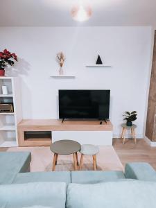 a living room with a couch and a flat screen tv at Mikasika - Duplex Apartment with seasonal swimming pool & walking distance from the beach in Cala del Moral