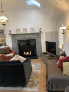 a living room with a fireplace and a couch at Oranuisce Thatch Cottage Ballyvaughan in Ballyvaughan