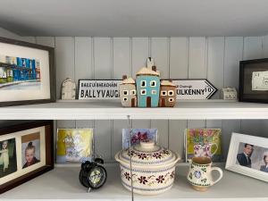 a shelf with pictures and a vase on it at Oranuisce Thatch Cottage Ballyvaughan in Ballyvaughan