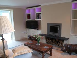 a living room with a fireplace and a tv at High Park Farm in York