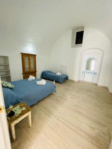 1 dormitorio con 1 cama azul y suelo de madera en Finestra sul Borgo Apt., en Acquarica del Capo