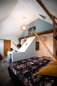 um quarto no sótão com uma cama e uma escada em B&B de Sfeerhoeve em Beilen