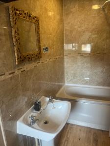 uma casa de banho com um lavatório e uma banheira em Villa Bianca B&B em Penrith