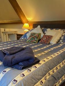 Una cama con mantas azules y almohadas. en Grange stables, en North Cadbury