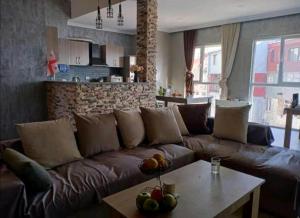 un sofá de cuero marrón en una sala de estar con mesa en Chase Dream Hostel追梦空间, en Batumi