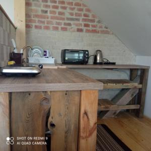 eine Küche mit einem Holztisch und einer Mikrowelle in der Unterkunft Zofiówka in Stare Jabłonki