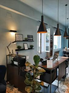 un ufficio con una scrivania, un computer e una pianta di Hotel Alabama by ALEhotels a Rimini