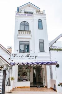 un magasin devant un bâtiment blanc avec un auvent violet dans l'établissement Hotel Thanh Nhung, à Đà Lạt