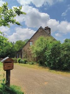 ein altes Backsteinhaus mit einem Briefkasten davor in der Unterkunft L'Aulnerie in La Chapelle-Cécelin