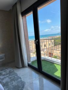 a room with a large window with a view of the ocean at Bella Address Hotel Beach in Saïdia