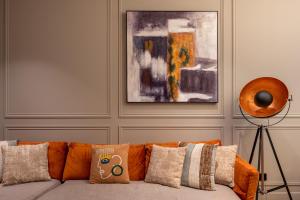 an orange couch with pillows in a living room at My Opéra in Paris