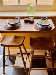 una mesa con platos y un taburete de madera en la cocina en Grange stables, en North Cadbury